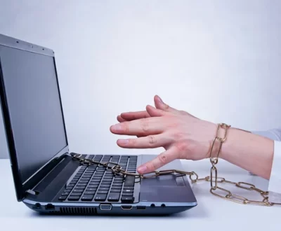 A photo of a woman chained to he laptop.
